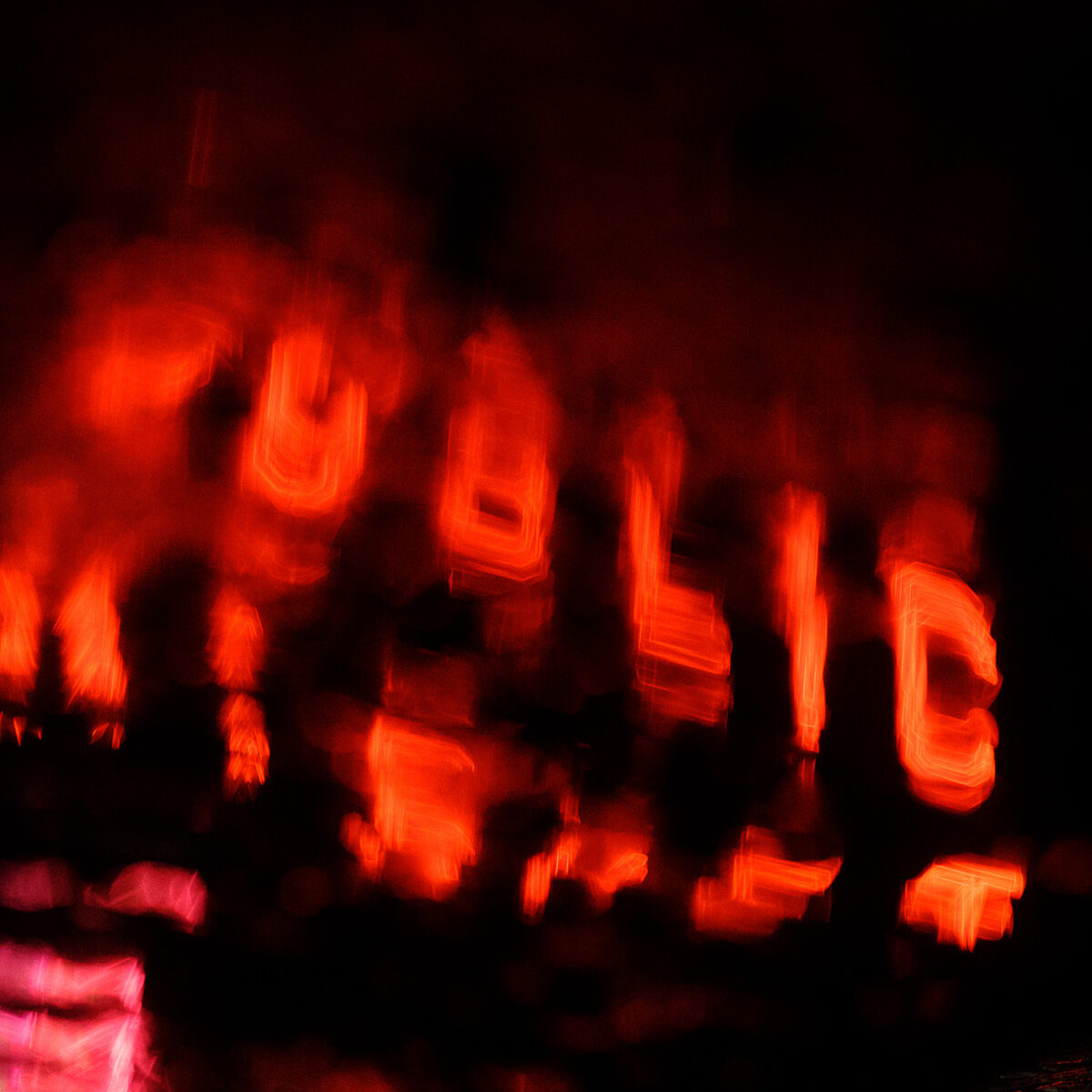 Blurred red-orange reflections on dark water with abstract neon shapes.